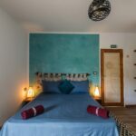 Chambre Fnar – lit double face au mur turquoise, Villa Bella Lina
