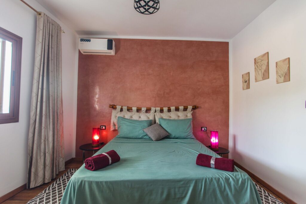 Chambre Tabouda – lit double face au mur terracotta, Villa Bella Lina