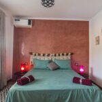 Chambre Tabouda – lit double face au mur terracotta, Villa Bella Lina