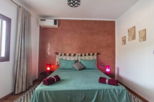 Chambre Tabouda – lit double face au mur terracotta, Villa Bella Lina