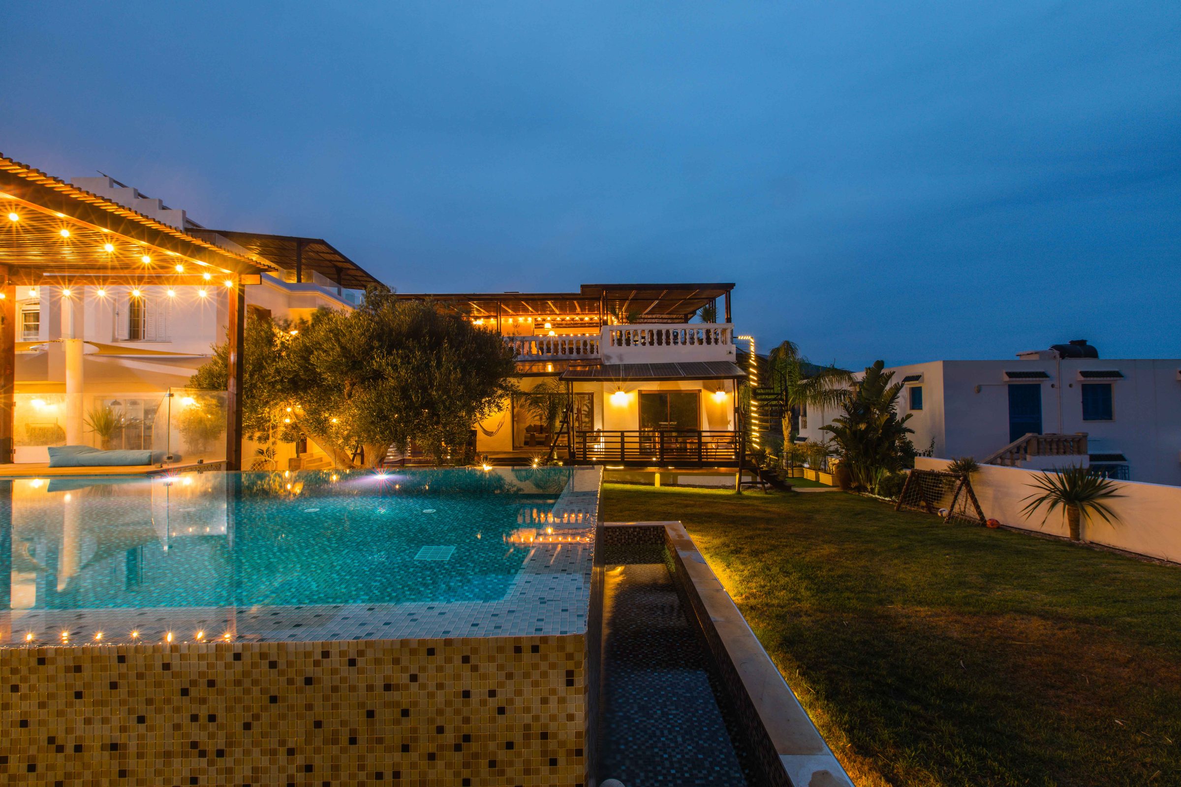 Piscine illuminée de Dar Lina maison de vacances à El Haouaria, au crépuscule